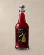 Dryspell 32 oz swing-top bottle, ruby kombucha, on plaster