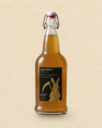 Dryspell 32 oz swing-top bottle, amber kombucha, on cream